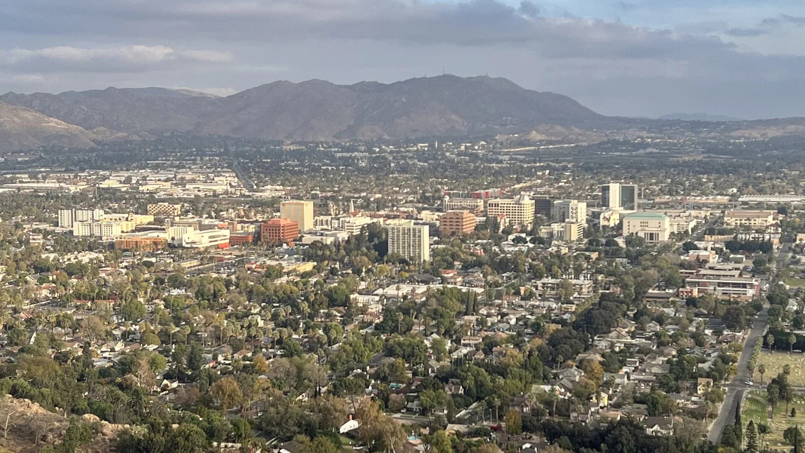 The skyline of downtown Riverside seen from near the top of Mount Rubidoux, with the Box Springs Mountains in the background. Downtown Riverside, Riverside, Riverside County, Calif